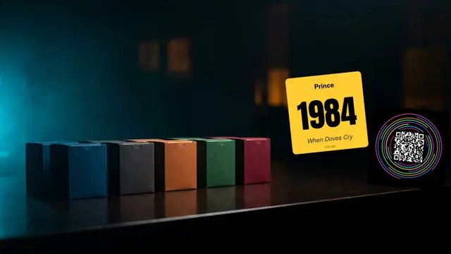 Hitify-Musikkarten, Laptop und Drucker auf einem dunklen Schreibtisch: Die Besten Hitster Erweiterungen 2026: Welche Passt zu Deiner Gruppe?